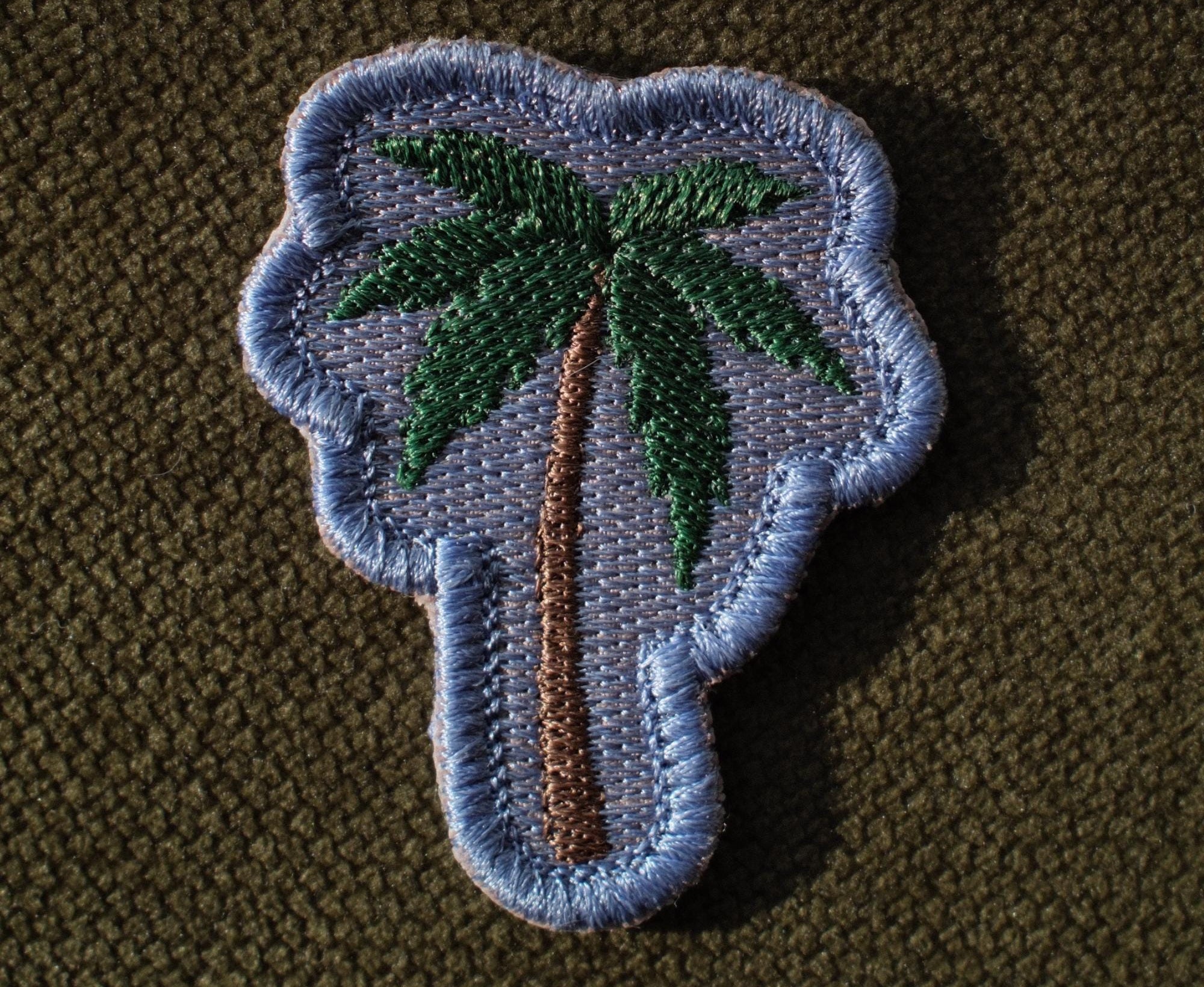 Palm tree embroidered coastal patch

Green palm tree patch with blue background

Palm tree patch embroidery and satin border detail

Coastal palm tree patch displayed on a beach bag

Palm tree patch iron-on and sew-on backing options