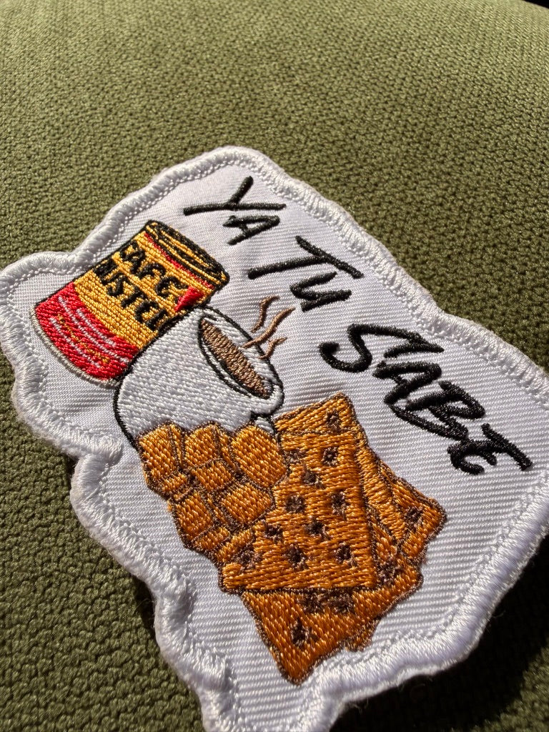 Ya Tu Sabe coffee and snacks embroidered patch

Latino culture coffee crackers and cheese patch

Ya Tu Sabe patch embroidery detail

Spanish phrase patch displayed on a denim jacket