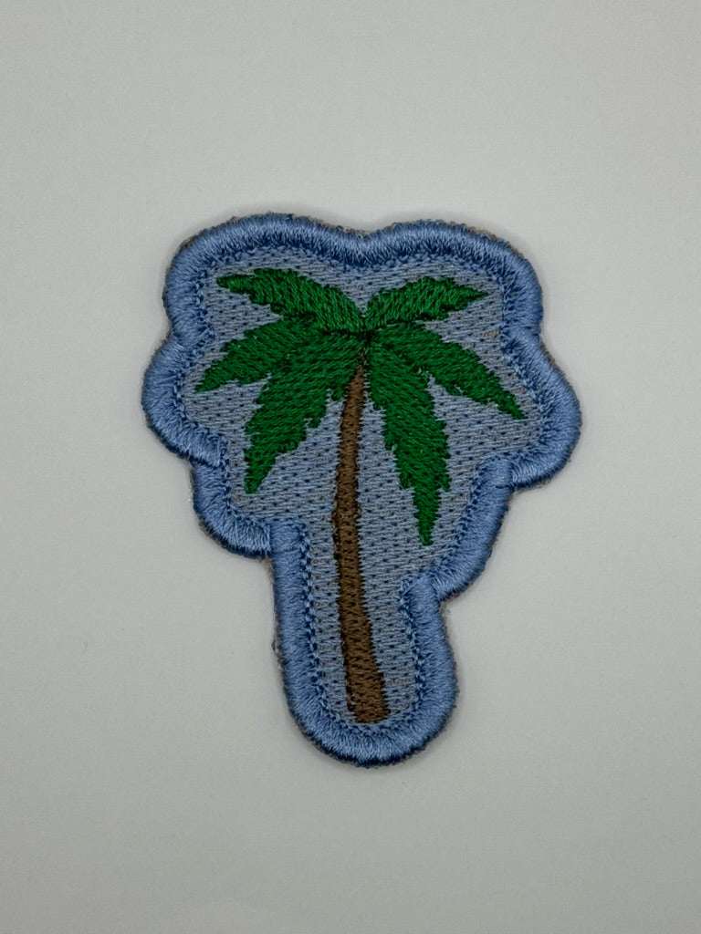Palm tree embroidered coastal patch

Green palm tree patch with blue background

Palm tree patch embroidery and satin border detail

Coastal palm tree patch displayed on a beach bag

Palm tree patch iron-on and sew-on backing options