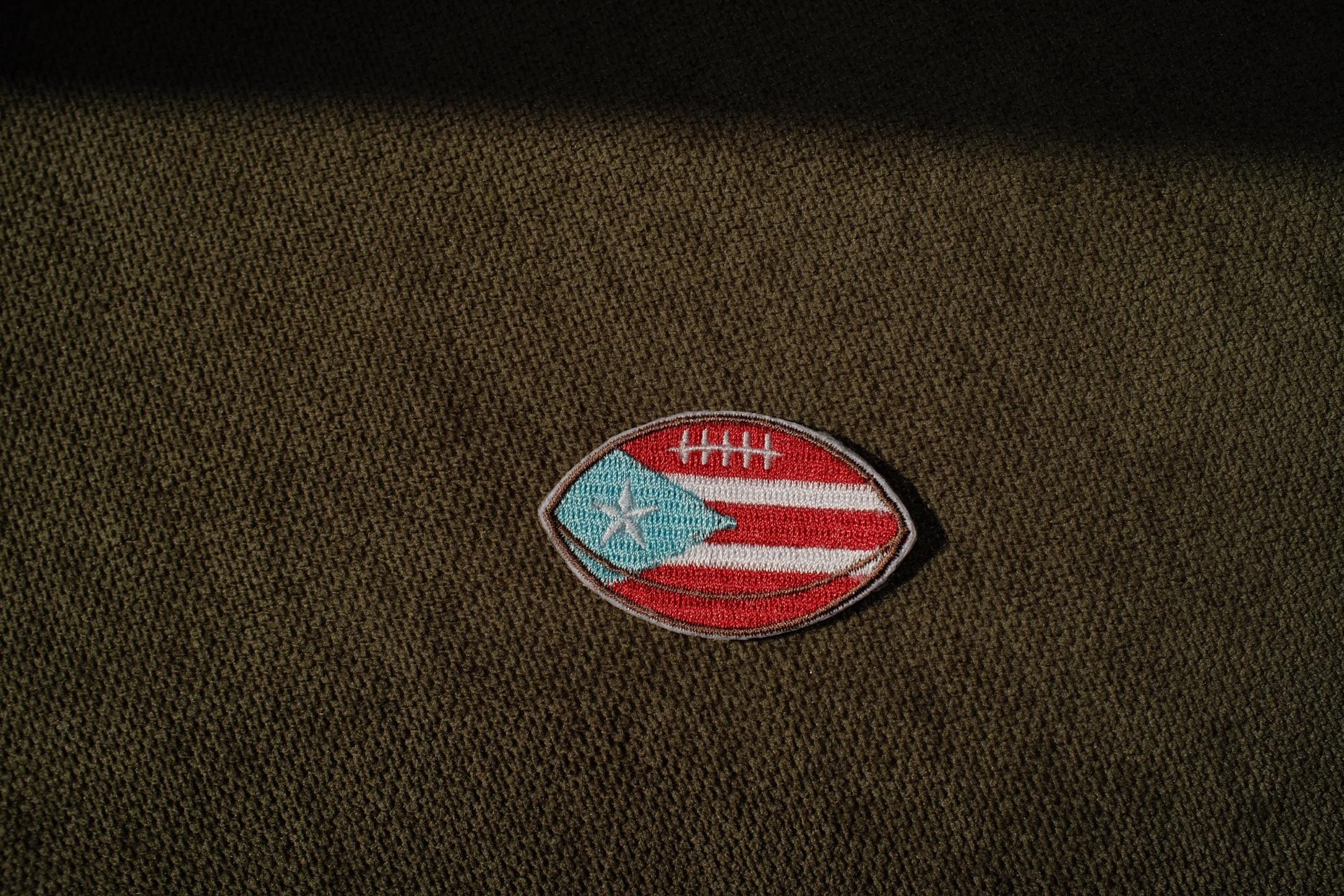 Puerto Rico flag football embroidered patch

Puerto Rican football iron-on patch

Boricua football patch embroidery detail

Puerto Rico football patch displayed on a jersey

Football patch iron-on and sew-on backing options